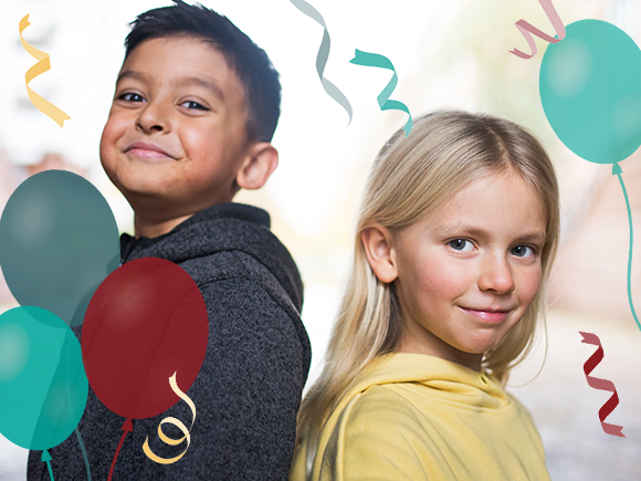 Flicka och pojke i lågstadieåldern står rygg mot rygg. Ballonger och serpentiner.