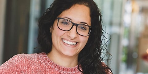 Tjej med lockigt brunt hår och rosa tröja