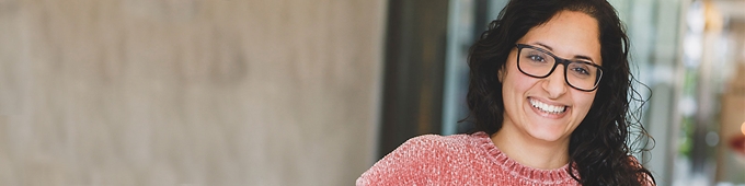 Tjej med lockigt brunt hår och rosa tröja