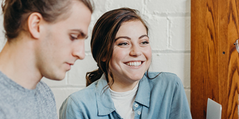 Tjej och kille sitter vid en dator