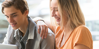 Kille och tjej sitter vid en dator