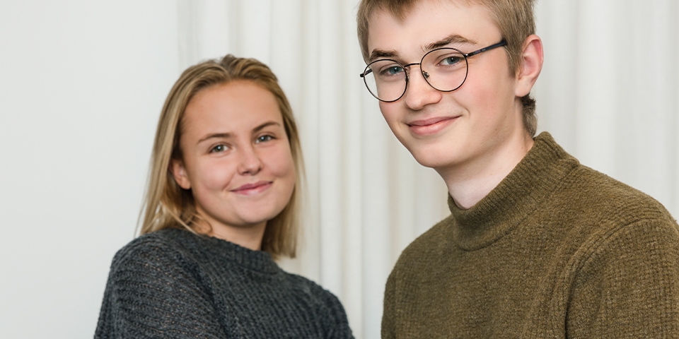 Två unga personer ler mot kameran