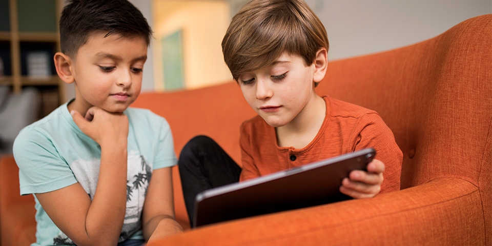 Två pojkar kollar ned mot en iPad