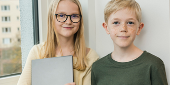 En kille och en tjej står tillsammans vid en vägg