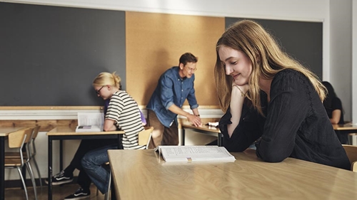Elever arbetar självständigt med stöd av läraren i ett klassrum