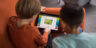 Två lågstadiekillar sitter vid en surfplatta