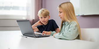 En kille och en tjej sitter vid en laptop