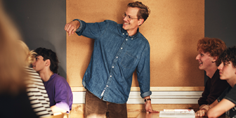 Lärare i jeansskjorta har en genomgång i ett klassrum