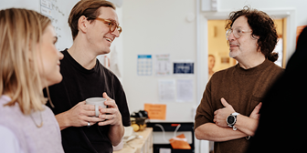 Tre lärare pratar med varandra i ett klassrum